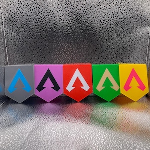 May include: Six small, plastic, triangular-shaped signs with a white arrow pointing upwards. The signs are in different colors: gray, purple, red, green, yellow, and pink.