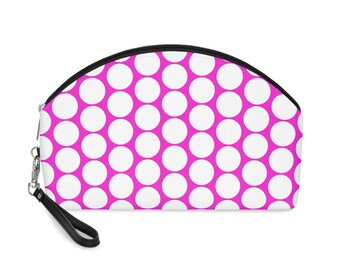 May include: A pink and white polka dot makeup bag with a black zipper and a black strap.