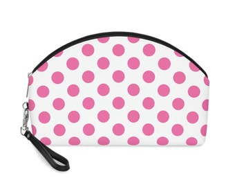 May include: A white and pink polka dot makeup bag with a black zipper and a black strap.