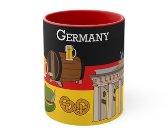 May include: A red and black ceramic mug with a German flag design. The mug features a pretzel, a beer stein, a barrel, and the Brandenburg Gate. The text "GERMANY" is printed on the mug.