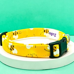 May include: Yellow dog collar with a bee pattern and the text "Zuber" on the collar.