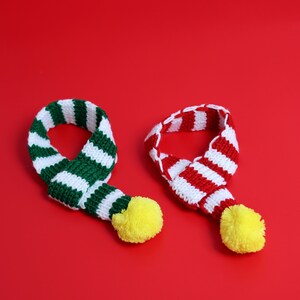 May include: Two striped knit scarves with pom-poms. One scarf is red and white, the other is green and white.