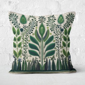 Op de afbeelding: Decoratief vierkant kussen met een botanisch ontwerp. Het kussen heeft een crèmekleurige achtergrond met een gedetailleerd patroon van groene bladeren, stelen en bloemelementen. Het ontwerp is symmetrisch, met een centraal boomachtig motief.