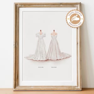May include: A framed print with two watercolour illustrations of wedding dresses. The white gowns have long trains and are displayed on mannequins. The dates 02.12.1994 and 08.10.2014 are printed below. A hand-drawn personalized seal is in the upper right corner.