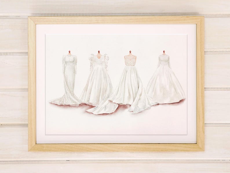 May include: Watercolor print of four white wedding dresses on mannequins. The dresses have varying styles, including long sleeves, lace details, and flowing skirts. The artwork is framed in a light wood frame.