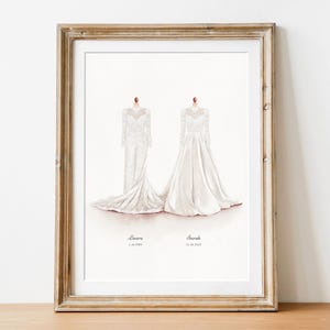 May include: Framed watercolor print featuring two white wedding dresses. The dresses are displayed on mannequins, with the names "Lauren" and "Sarah" and their wedding dates below. The frame is a distressed gold color.