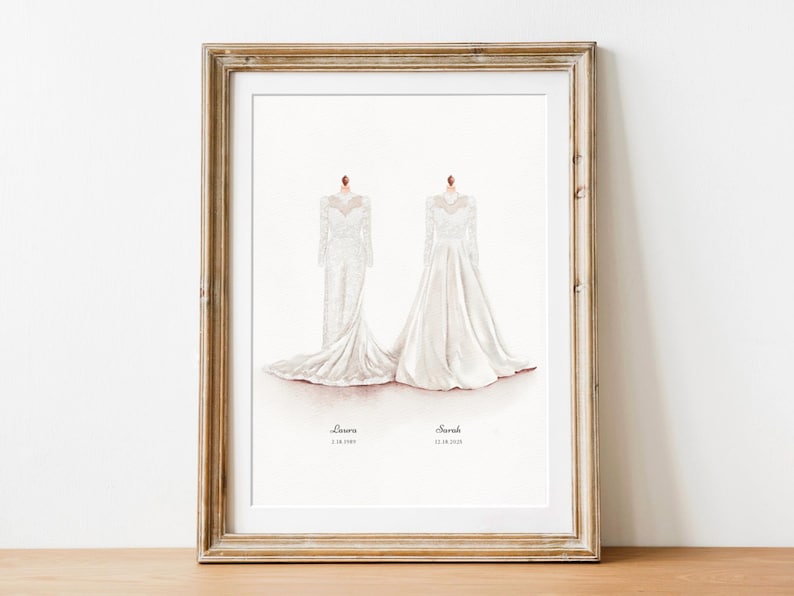 May include: Framed watercolor print featuring two white wedding dresses. The dresses are displayed on mannequins, with the names "Lauren" and "Sarah" and their wedding dates below. The frame is a distressed gold color.