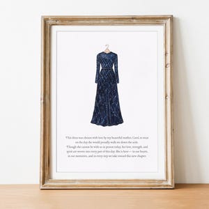 May include: A framed print featuring a navy blue, long-sleeved gown with a patterned design, hanging on a hanger. The artwork is set against a white background, within a wooden frame. Text is present at the bottom of the image.