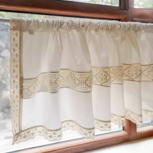 May include: White sheer valance with a delicate lace trim. The lace trim features a repeating pattern of small flowers and geometric shapes.