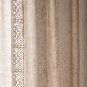 Può includere: Un paio di tende bianche e trasparenti con un delicato bordo in pizzo. Le tende sono realizzate in un tessuto leggero e hanno una texture sottile.