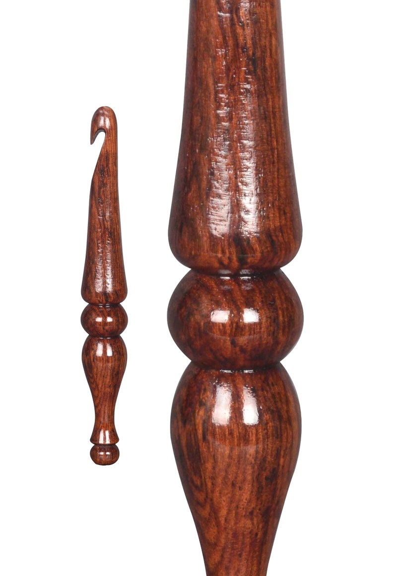 May include: A set of two wooden crochet hooks with a dark brown wood grain finish. The larger hook has a bulbous handle with three rounded sections. The smaller hook has a more traditional handle with two rounded sections.