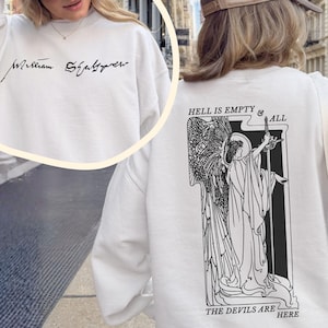 May include: White sweatshirt featuring the text "William Shakespeare" in black script on the front. The back of the sweatshirt has a black and white graphic with the text "Hell is Empty & All The Devils Are Here".