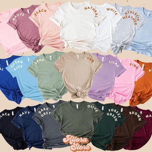 May include: A selection of short-sleeved t-shirts in a range of colours, such as pink, blue, and green. Each shirt has a different colour name printed on the sleeve. The shirts are displayed in rows, showcasing a variety of shades.