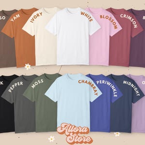 May include: A collection of short-sleeved t-shirts in various colors, including espresso, yam, ivory, white, blossom, crimson, berry, black, pepper, moss, chambray, periwinkle, midnight, and orchid. The text "Allora Store" is at the bottom.