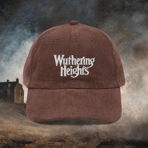 Dark Brown cotton corduroy baseball cap with adjustable strap and white embroidered text reading 'Wuthering Heights' inspired by the book Wuthering Heights By Emily Brontë.