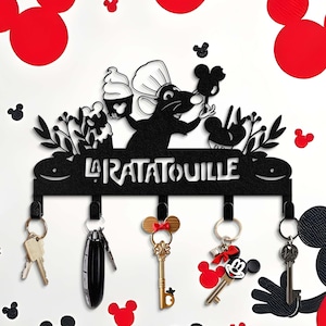May include: Black metal key holder with a silhouette of Remy the rat from the movie Ratatouille. The holder has five hooks and the text "La Ratatouille" is written on the top.