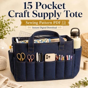 Op de afbeelding: Een donkerblauwe stoffen tas voor knutselspullen met 15 buitenzakken, voorzien van de tekst 15 Pocket Craft Supply Tote Sewing Pattern PDF Instant Digital Download. De tas bevat scharen, pennen, een smartphone en clips, met een waterfles in een zijvak.