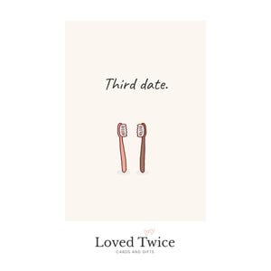 May include: A greeting card with the text "Third date." features two cartoon toothbrushes, one pink and one brown, on a cream background. The bottom of the card displays the "Loved Twice" logo with the words "Cards and Gifts."