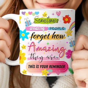May include: White ceramic mug with a colourful design featuring the text "Sometimes amazing people forget how amazing they are - This is your reminder".