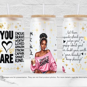 May include: Three glass tumblers with bamboo lids and straws. The tumblers feature inspirational quotes and graphics in gold and black. One tumbler says "YOU ARE" with a heart. Another says "CHOOSE TO SHINE". The third says "keep shining!"