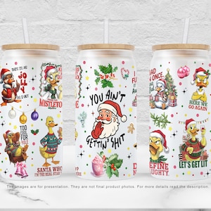 Könnte beinhalten: Drei Glaskrüge in Dosenform mit Bambusdeckeln und weißen Strohhalmen. Jeder Becher hat ein festliches Weihnachtsdesign mit Zeichentrickenten und dem Weihnachtsmann. Der Text enthält Sätze wie "You Ain't Gettin' Shit" und "Let's Get Lit."