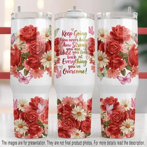 May include: White tumbler featuring a floral design with red roses, pink daisies, and butterflies. The tumbler has the text "Keep Going, You never know how Strong you are Until you look back at Everything you've Overcome!"