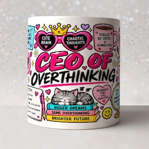 Könnte beinhalten: Ein weißer Keramikbecher mit einem bunten Grafikdesign und dem Text CEO OF OVERTHINKING. Die Illustration zeigt eine rosafarbene herzförmige Brille, eine Krone, eine schlafende graue getigerte Katze auf drei Büchern, eine Kaffeetasse und eine Liste.