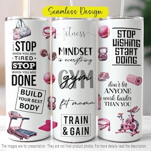 May include: White tumbler with fitness-themed graphics and text. The design includes a gym bag, dumbbells, kettlebells, and a treadmill. Text includes "STOP", "MINDSET is everything", and "TRAIN & GAIN". The tumbler has a seamless design.