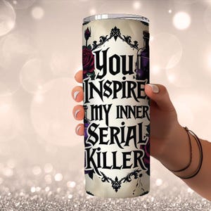 May include: A tall, cylindrical tumbler with the text "You Inspire My Inner Serial Killer" in black gothic lettering. The design includes dark red roses and a purple potion bottle on a cream background.