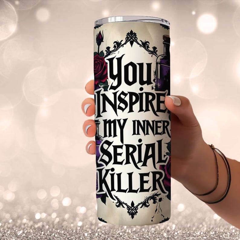 May include: A tall, cylindrical tumbler with the text "You Inspire My Inner Serial Killer" in black gothic lettering. The design includes dark red roses and a purple potion bottle on a cream background.