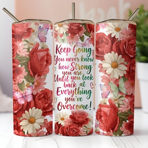 May include: A stainless steel tumbler with a floral design featuring red roses, daisies, and butterflies. The tumbler has the text "Keep Going, You never know how Strong you are Until you look back at Everything you've Overcome!"