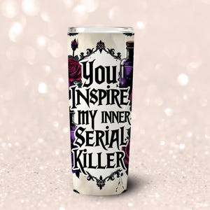 May include: A tall, cylindrical tumbler with the text "You Inspire My Inner Serial Killer" in black gothic lettering. The design includes dark red roses, purple potion bottles, and ornate black frames against a cream background.
