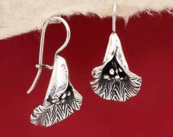 May include: A pair of silver flower-shaped dangle earrings. The earrings are made of sterling silver and have a delicate, textured design.