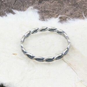 Op de afbeelding: Een zilveren gevlochten armband met een gladde, gepolijste afwerking.