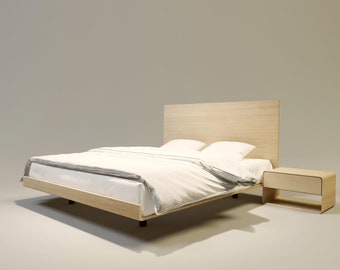 Puede incluir: Un juego de dormitorio moderno con una estructura de cama de madera clara con cabecero, ropa de cama blanca y una mesita de noche a juego. La cama está hecha con una colcha y almohadas blancas. La mesita de noche tiene un cajón.