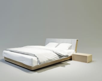 Puede incluir: Una cama moderna con estructura de madera clara y cabecero tapizado gris. La cama está hecha con ropa de cama blanca y dos almohadas. Una mesita de noche a juego está al lado de la cama.