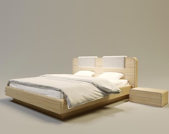Puede incluir: Una cama de madera moderna con una mesita de noche a juego. La cama tiene un acabado de madera clara, un cabecero con dos paneles tapizados y un edredón de color claro. La mesita de noche tiene un diseño minimalista con un cajón.