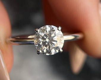 May include: A silver ring with a round, clear diamond.