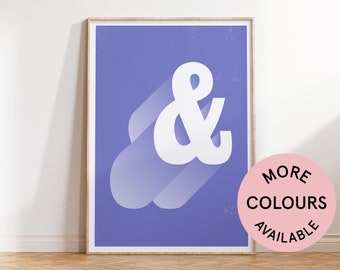 May include: A purple and white ampersand symbol with a shadow effect. The ampersand is in a minimalist style and is framed in a wooden frame. The text "MORE COLOURS AVAILABLE" is on a pink circle.
