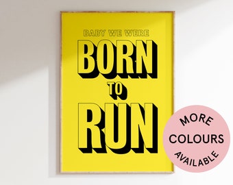 May include: A yellow poster with black text that reads "Baby we were born to run". The poster has a wooden frame. A pink circle with white text that reads "More Colours Available" is in the lower right corner of the image.