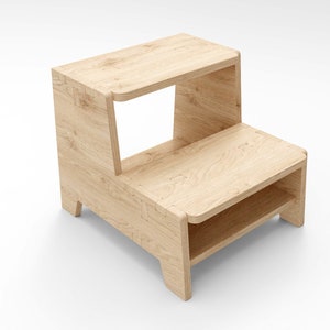 Puede incluir: Un taburete de madera de dos peldaños con un acabado marrón claro. El taburete tiene un peldaño superior rectangular y un peldaño inferior rectangular más pequeño. Los peldaños están conectados por una estructura de soporte vertical con un espacio abierto en el medio.
