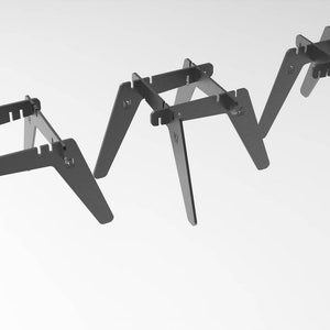 Può includere: Tre sgabelli pieghevoli in metallo nero con un design semplice e geometrico. Ogni sgabello ha un piano quadrato e quattro gambe che si ripiegano per una facile conservazione.