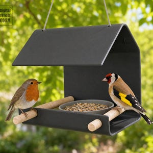 Puede incluir: Un comedero para pájaros moderno, de color gris oscuro, con techo, dos perchas de madera y un cuenco pequeño lleno de semillas. Un petirrojo europeo y un jilguero están posados en el comedero. La imagen incluye el texto "Digital files ONLY".