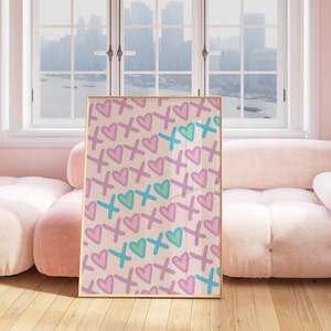 Könnte beinhalten: Ein gerahmter Druck mit einem Muster aus rosa und lila Herzen und blauen und grünen Kreuzen auf cremefarbenem Hintergrund.