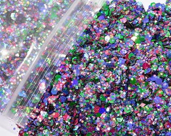 May include: A close-up of a bag of colorful glitter. The glitter is a mix of green, blue, pink, and purple. The glitter is in a clear plastic bag.