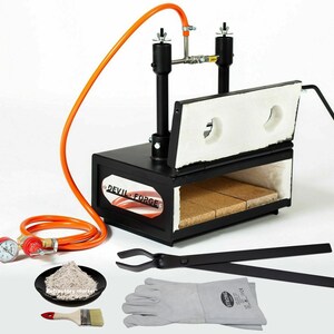 May include: A black metal forge with an orange hose attached. The forge has a hinged door and a brick lining. The forge is accompanied by a pair of tongs, a pair of leather gloves, a small bag of refractory mortar, a paintbrush, and a pressure gauge.