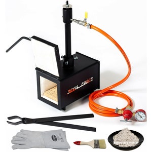 Puede incluir: Un horno de metal negro con una manguera naranja y un manómetro. El horno tiene una pequeña puerta y un asa. El horno está etiquetado como "Devil Forge". La imagen también incluye un par de tenazas, un par de guantes de soldadura, un pincel y un pequeño cuenco de mortero refractario.