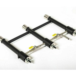 Puede incluir: Un marco de metal negro con tres tubos de quemador de gas ajustables. Cada tubo tiene una válvula y un extremo roscado para conectar a una línea de gas.