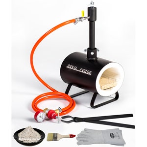 May include: Black metal forge with an orange hose, a red and silver regulator, a pair of tongs, a pair of gloves, a brush, and a bag of refractory mortar. The forge has a white ceramic lining and the text "DEVIL FORGE" is printed on the side.