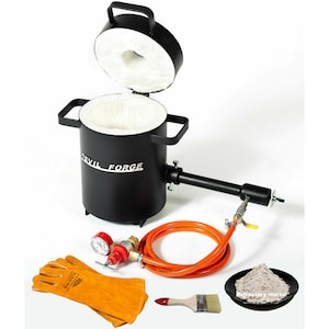 May include: Black metal furnace with a white ceramic lining, a red and black gas regulator, an orange hose, a pair of leather gloves, a paintbrush, and a small bowl of grey refractory mortar. The furnace has a handle and the text "DEVIL FORGE" on the side.
